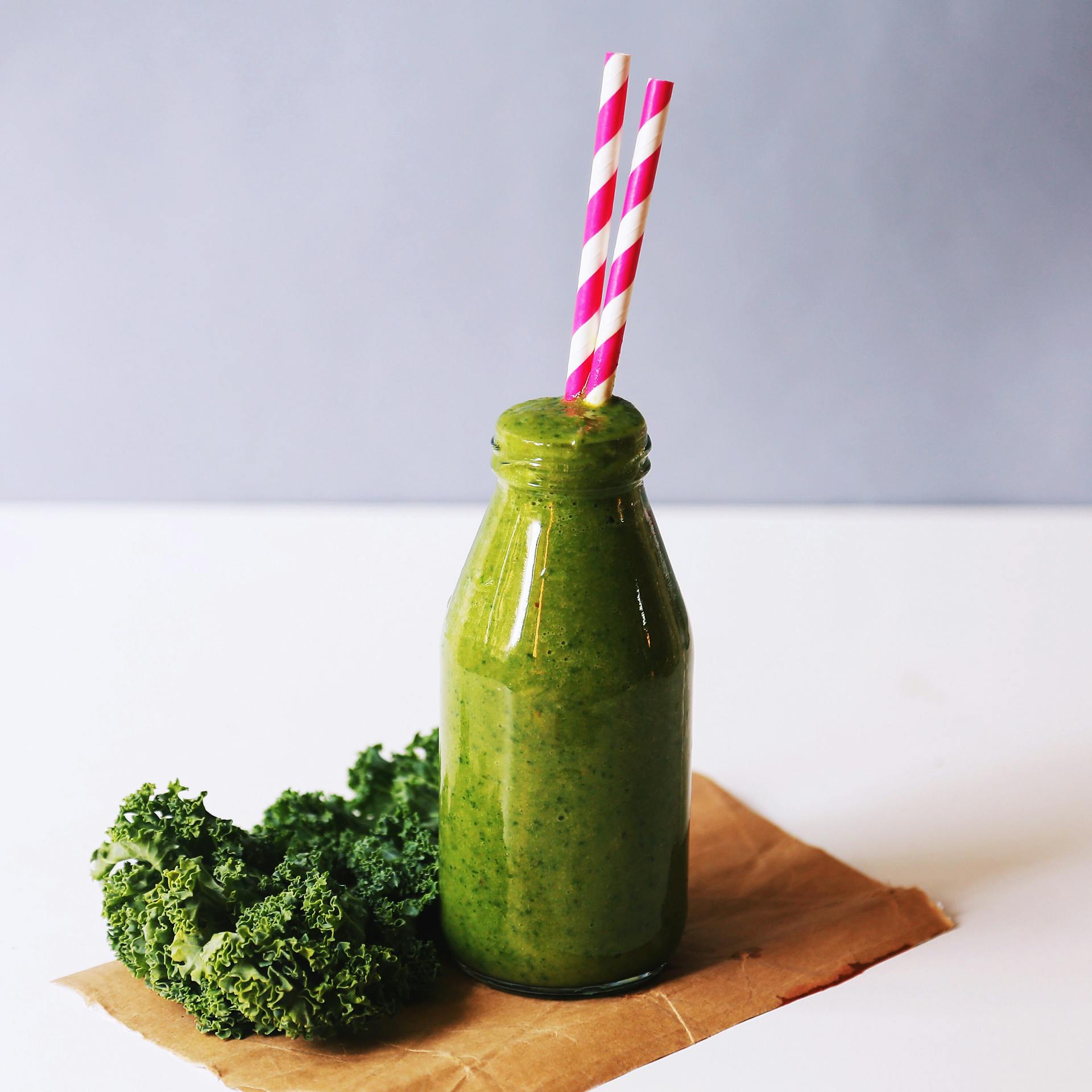 Green supplement powder shake in a glass bottle - AG1 alternative greens powder